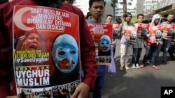 Muslim protesters hold banners during a rally outside China's embassy in Jakarta, Indonesia, Friday, Dec. 21, 2018. 