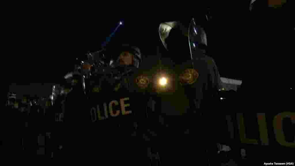 Police officers in riot gear gather outside the Ferguson Police Department, in Ferguson, Missouri, Nov. 25, 2014.