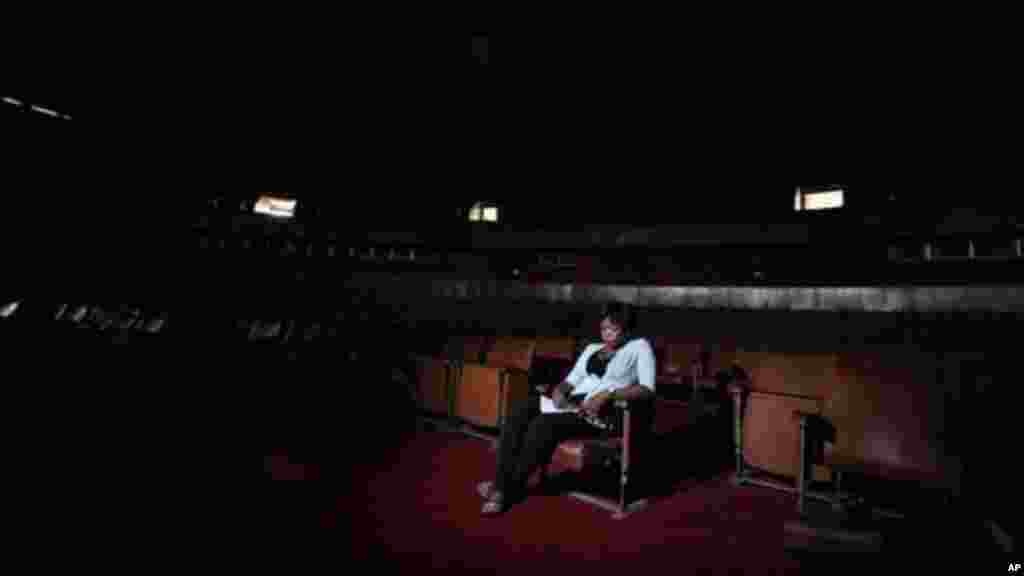 A worker sits in the abandoned bowl theater of Nigeria's National Theatre in Lagos, Nigeria.