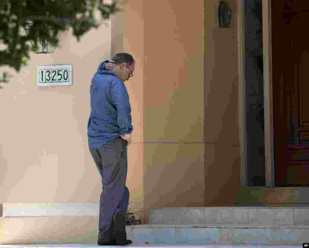 Seorang laki-laki yang tidak diketahui identitasnya menunggu di depan rumah keluarga wartawan Steven Sotloff, Selasa, 2 September 2014 di Pinecrest, Florida. Video internet yang diunggah hari Selasa menunjukkan pemenggalan Sotloff oleh kelompok ISIS, yang hilang di Suriah tahun lalu.