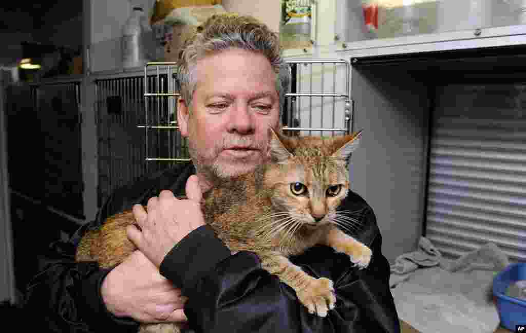 Bill Ryan of Inwood, New York, comforts his cat before leaving her at a pet shelter. Pet owners could drop off their pets at the shelter and afterwards seek shelter for themselves before the arrival of the storm.