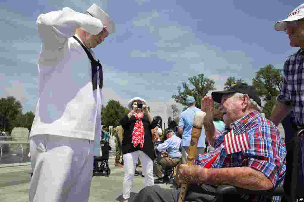 Navy Petty Officer Kevin Smith, left, salutes WWII veteran Harold Noel, 98, who was a B-24 navigator during WWII and was shot down and imprisoned as a POW at Stalag Luft III, at the World War II Memorial in Washington D.C. during a ceremony in honor of the 70th anniversary of Victory in Europe Day (VE Day), May 8, 2015,