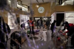 People loot a Versace store during a protest condemning the arrest of rap singer Pablo Hasél in Barcelona, Spain, Feb. 20, 2021.