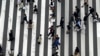 FILE - People walk in the Ginza shopping district in Tokyo, March 31, 2023. A report issued Wednesday by the Organization for Economic Cooperation and Development predicts Japan's economy is on pace to go from a decline of 0.1% this year to 1.4% growth in 2025.