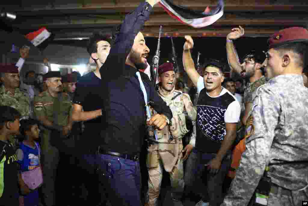 نیروهای عراقی و شهروندان آن کشور در حال رقص و پایکوبی با در دست داشتن پرچم عراق در بصره