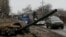 Empty buses wait along a road beside a burnt-out tank turret while travelling in the direction of Debaltseve to evacuate the residents, in Vuhlehirsk, Donetsk region, Feb. 6, 2015.
