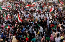 FILE - Sudanese people celebrate on the streets of Khartoum after the ruling military council and a coalition of opposition and protest groups reached agreement to share power during a transition period leading to elections, July 5, 2019.