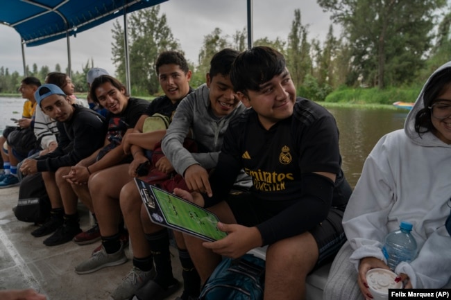 Amateur soccer players from the Tumbados team travel in a traditional canoe in the Xochimilco borough of Mexico City, on Sunday, October 20, 2024. (AP Photo/Felix Marquez)