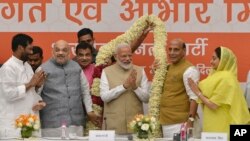 Bharatiya Janata Party (BJP) President Amit Shah (2nd-L) and cabinet members present a garland to Indian Prime Minister Narendra Modi at a function to thank cabinet members for their service in the term that is about to end, in New Delhi, India, May 21, 2019.