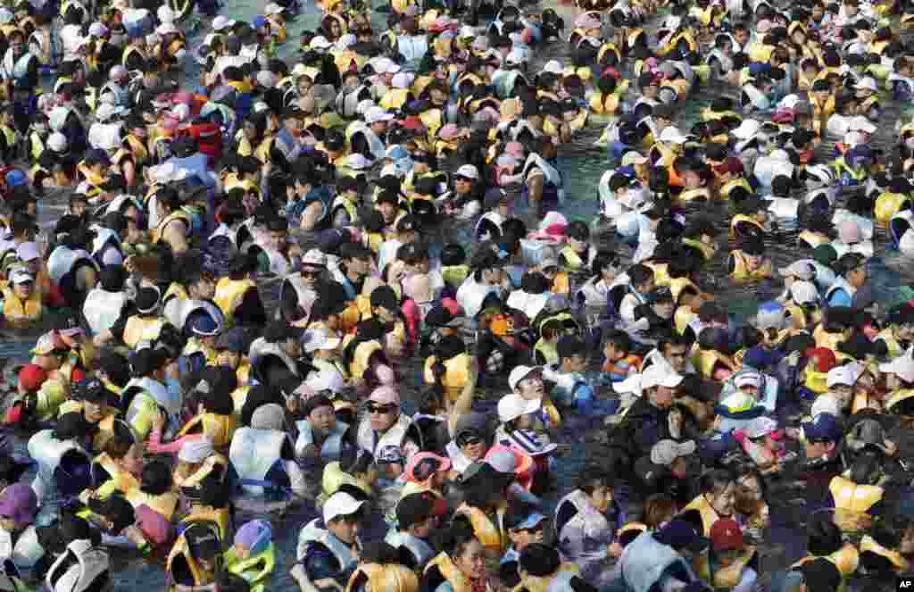 A large group of people crowd into the Caribbean Bay swimming pool trying to escape the heat in Yongin, South Korea.