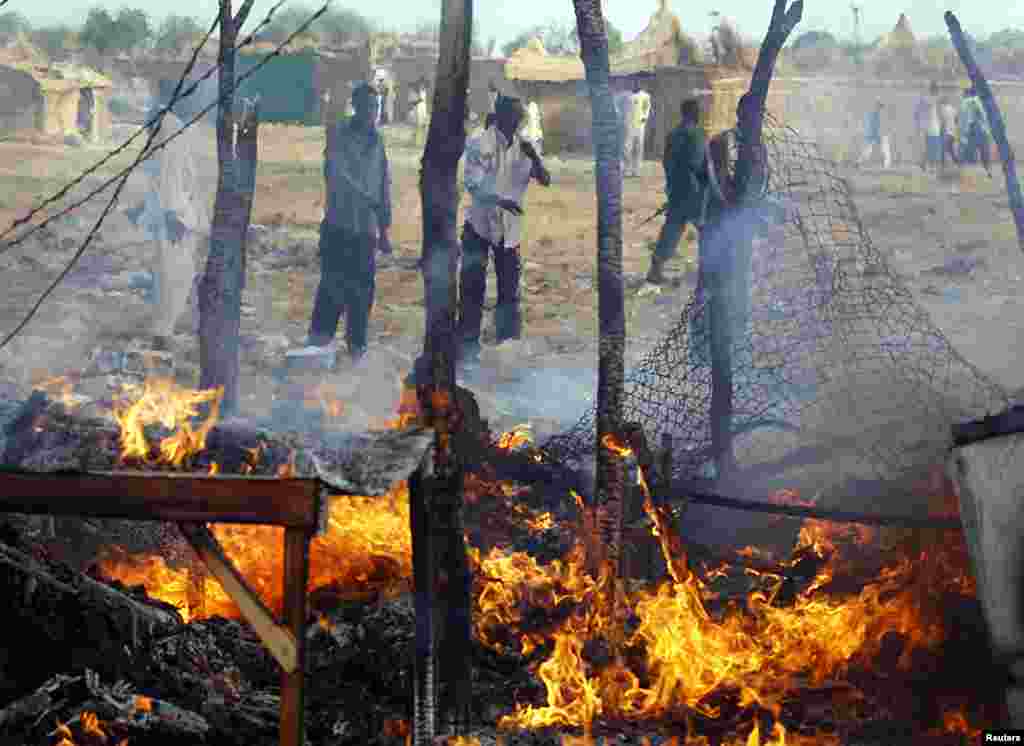 Men look at a market destroyed by an air strike by the Sudanese air force in Rubkona near Bentiu, South Sudan, April 23, 2012. (Reuters)