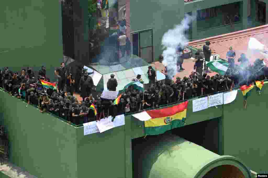Oficiales de policía se reúnen en una terraza de la sede de la policía con carteles que dicen &quot;motín policial&quot;, durante las protestas contra el presidente de Bolivia, Evo Morales, en Santa Cruz de la Sierra, Bolivia, el sábado.
