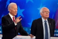 Mantan Wakil Presiden AS yang juga calon presiden dari Partai Demokrat, Joe Biden, kiri, berbicara sebagai calon presiden dari Partai Demokrat, Senator Bernie Sanders dalam debat utama pemilihan presiden Partai Demokrat, Rabu, 20 November 2019, di Atlanta. (Foto