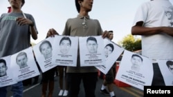 People hold photographs of missing students during a march in their support in Guadalajara Oct. 8, 2014.