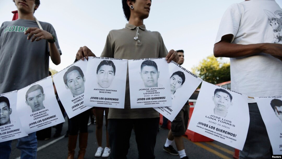 People hold photographs of missing students during a march in their support in Guadalajara Oct. 8, 2014.