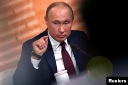 Russian President Vladimir Putin gestures during his annual end-of-year news conference in Moscow, Dec. 19, 2019.