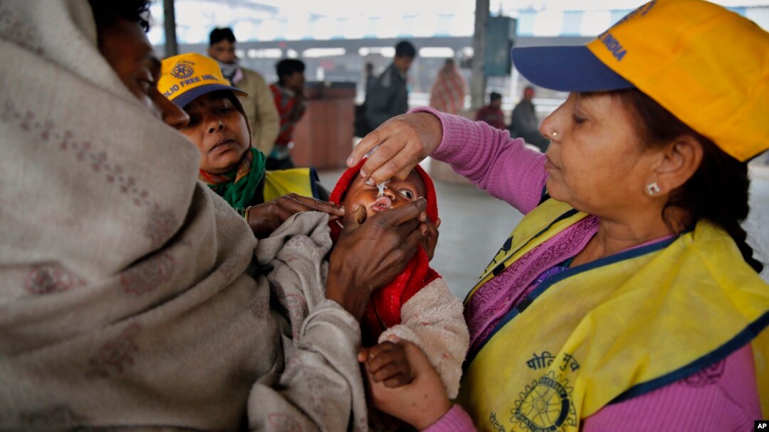 A medical volunteer administers polio immunization drops to a child at a railway station in Allahabad, India, Jan. 13, 2014.