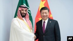 FILE - In this photo released by China's Xinhua News Agency, Chinese President Xi Jinping, right, shakes hands with Saudi Arabia's Crown Prince Mohammed bin Salman during a meeting on the sidelines of the G20 summit in Buenos Aires, Argentina, Nov. 30, 2018.