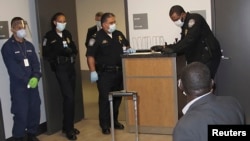 U.S. Customs and Border Protection officers perform enhanced passenger screening of an international traveler, who recently visited Guinea, at Atlanta's International Airport Oct. 16, 2014.