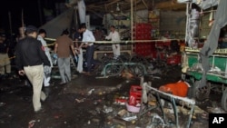 Pakistani police and security officers examine the site of an explosion in Multan, Pakistan, Sunday, Sept. 13, 2015. 