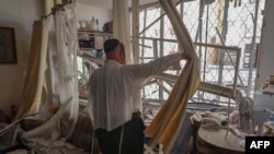 A man inspects a damaged apartment in a building which was hit with a rocket launched from Lebanon, in Kiryat Yam near Israel's northern city of Haifa on Oct. 8, 2024.