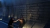 A mourner places a flag in the Empty Sky memorial on the morning of the 15th anniversary of the 9/11 attacks in New Jersey, Sept. 11, 2016.