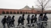 Oficiales de la Guardia Nacional Rusa caminan junto al muro del Kremlin en Moscú el 23 de marzo de 2024.