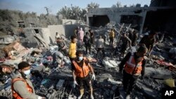 FILE - Palestinians inspect the damage of a destroyed house following Israeli airstrikes on Khan Younis, Southern Gaza Strip, Sunday, December 31, 2023.