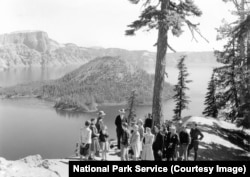 A park ranger speaks with visitors in the early days of Crater Lake National Park