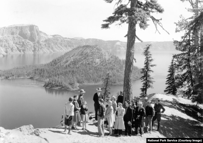 A park ranger speaks with visitors in the early days of Crater Lake National Park