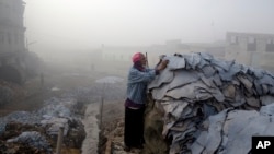 FILE - In this Dec. 19, 2014 photo, Mohammad Habib, 90, collects pieces of hide to process on a cold and foggy morning at the Hazaribagh tannery area in Dhaka, Bangladesh. 