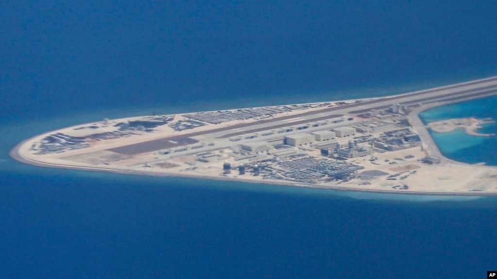 菲律宾空军一架运输机在南中国海南沙群岛的中国造的人造岛礁渚碧礁上空飞越时拍摄的照片,显示人造岛礁上的简易机场和建筑物。(2017年4月21日)