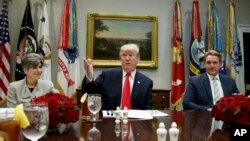 Presiden Donald Trump didampingi oleh Senator Joni Ernst (partai Republik dari Iowa, kiri) dan Senator Jeff Flake (partai Republik dari Arizona, kanan), sebelum jamuan makan siang di Ruang Roosevelt Gedung Putih, Selasa, 5 Desember 2017, di Washington, D.C.