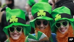 FILE - People dress in the emerald green to honour Ireland's Saint Partick, as they enjoy the atmosphere during the St Patrick's day parade in Dublin, Ireland, March, 17, 2014. (AP Photo/Peter Morrison)