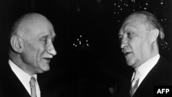 FILE - French Foreign Minister Robert Schuman, left, and German Chancellor Konrad Adenauer chat during the reception that followed the signing of the treaty establishing the European Defense Community (Treaty of Paris) in Paris, May 27, 1952.