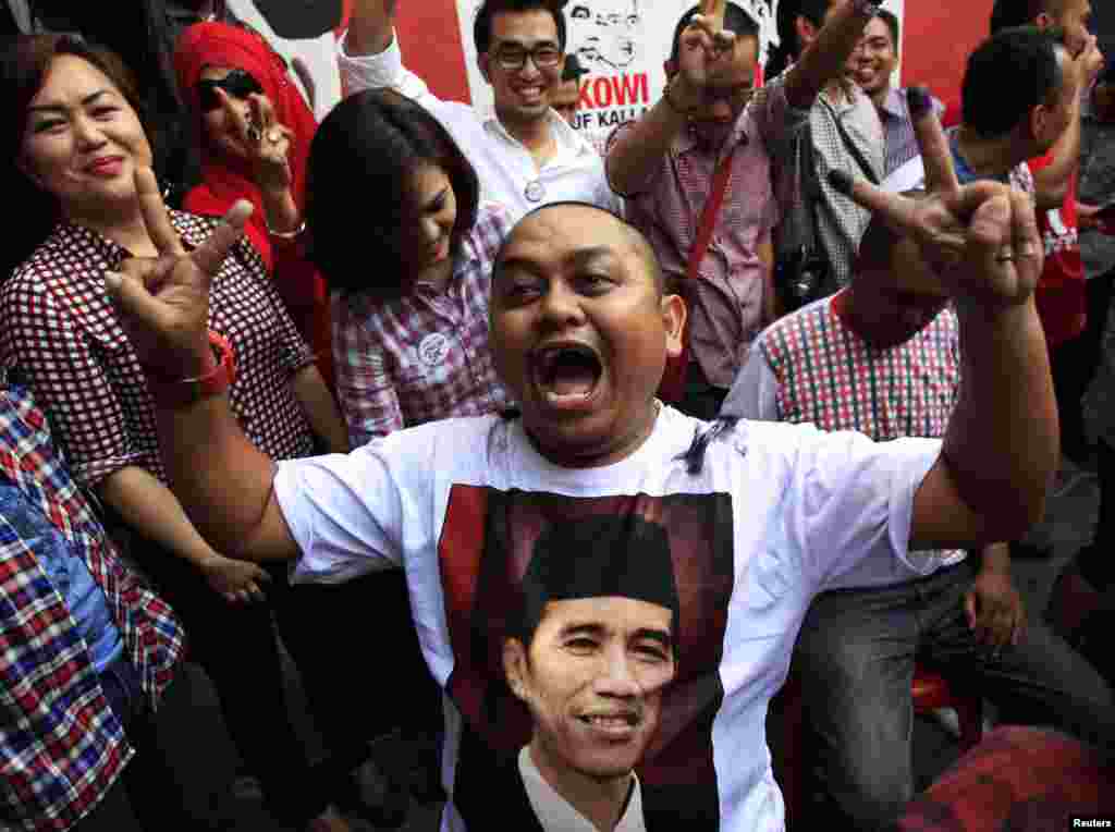 Supporters of Jakarta governor Joko "Jokowi" Widodo celebrate during an official vote count for the country's presidential election in Makassar, South Sulawesi, Indonesia, July 9, 2014.