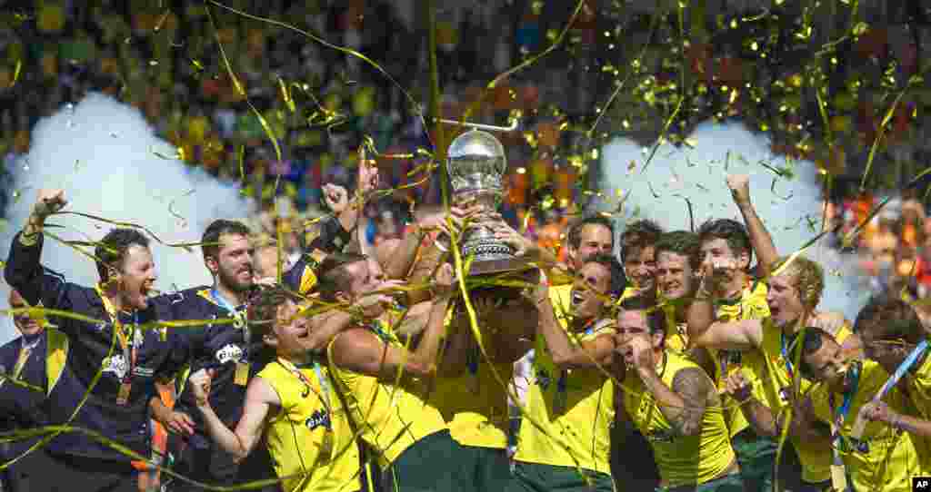 Australian players celebrate holding the trophy after winning the men&#39;s final of the Field Hockey World Cup between Australia and The Netherlands in The Hague, Netherlands. Australia beat the Netherlands with a 6-1 score.