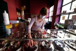 Simona Papagno prepares for home deliveries and readies her Criollo ice cream and coffee bar for takeaway orders for the reopening on May 4 due to the partial easing of restrictions during the coronavirus pandemic, Saturday, May 2, 2020, in Rome, Italy.