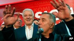 FILE - Montenegro's Prime Minister and long-ruling Democratic Party of Socialists leader Milo Djukanovic, front, speaks in his headquarters while his deputy, Dusko Markovic, stands behind him in Podgorica, Montenegro, Oct. 17, 2016.