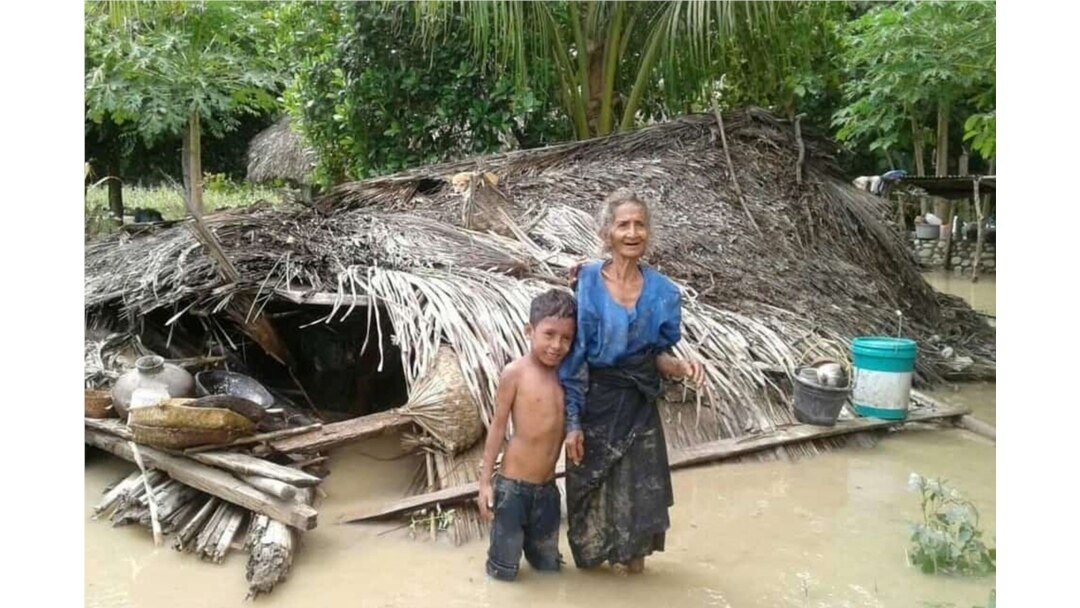 Seorang nenek dan cucunya berdiri depan rumah mereka yang rusak akibat banjir bandang di Desa Haitimuk di Flores Timur pada 4 April 2021. Banjir bandang dan tanah longsor melanda Indonesia bagian timur dan negara tetangga, Timor Leste. (Foto: AFP/Joy Chr