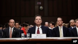 Former FBI director James Comey listens to the committee chairman at the beginning of the Senate Intelligence Committee hearing on Capitol Hill, June 8, 2017, in Washington. 