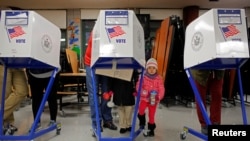 Myla Gibson, 3, waits as her father Ken Gibson fills out a ballot for the U.S presidential election at the James Weldon Johnson school in the East Harlem neighborhood of Manhattan, New York City, Nov 8, 2016. President Donald Trump claims that up to 5 million votes were cast illegally in the November election, costing him the popular vote.
