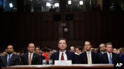 Cựu giám đốc FBI James Comey nghe Chủ tịch Ủy ban Tình báo Thượng viện phát biểu vào đầu phiên điều trần trong Quốc hội, ngày 8 tháng 6, 2017, ở Washington. 