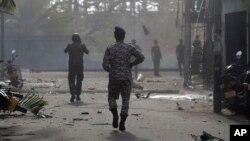 Sri Lankan security forces approach the site after a vehicle parked near St. Anthony's shrine exploded in Colombo, Sri Lanka, Monday, April 22, 2019.