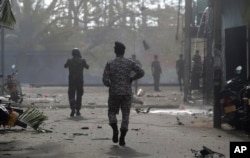 Sri Lankan security forces approach the site after a vehicle parked near St. Anthony's shrine exploded in Colombo, Sri Lanka, April 22, 2019.