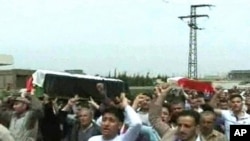 A handout picture released by the Syrian Arab News Agency (SANA) shows people gathering for the funeral of two people allegedly killed in recent clashes in Homs, north of Damascus, April 19, 2011