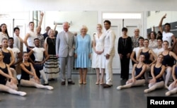 Britain's Prince Charles and Camilla, Duchess of Cornwall together with Carlos Acosta, founder and director of Acosta Danza pose with staff and ballet dancers during a visit to the Acosta Dance Company in Havana, March 25, 2019.