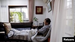 En la foto de archivo Yasuda Toyoko (95), que tiene cáncer de estómago y demencia, mira televisión en la sala de estar de la casa de su hija en Tokio, Japón.