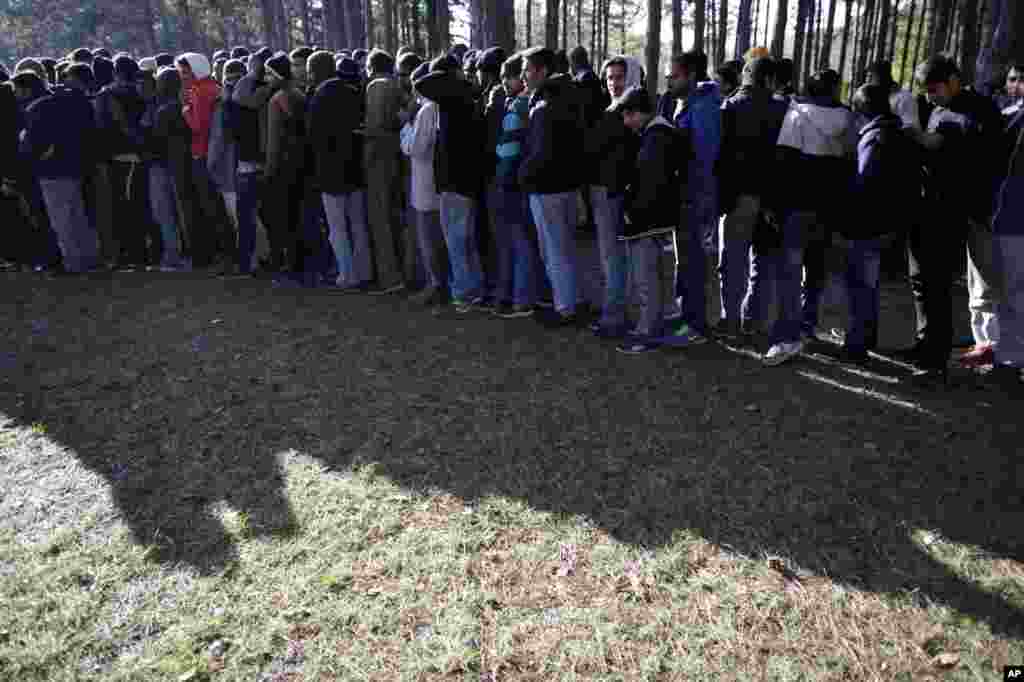 Di foto yang diambil pada hari Selasa, 19 November 2013 ini, para imigran mengantri makanan di pusat pencari suaka di desa Bogovadja, 50 km selatan ibukota Serbia, Belgrade. 