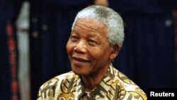 FILE - Nelson Mandela prepares to shoot a basketball hoop with the Harlem Globetrotters as part of his birthday celebrations, July 4, 1997.